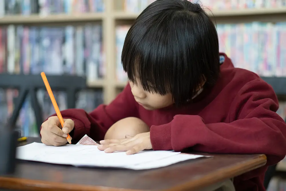 boy writing at desk